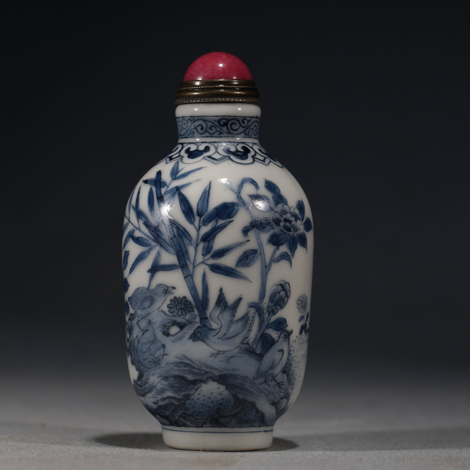 A Chinese Blue and White Porcelain Ovoid Snuff Bottle with Birds,Bamboo and Cockerel,Qianlong Mark: A blue and white porcelain snuff bottle of ovoid form,painted with a lively scene of various birds on bamboo branches and rockwork on one side,and a cockerel,a hen and chicks in a garden setting on th