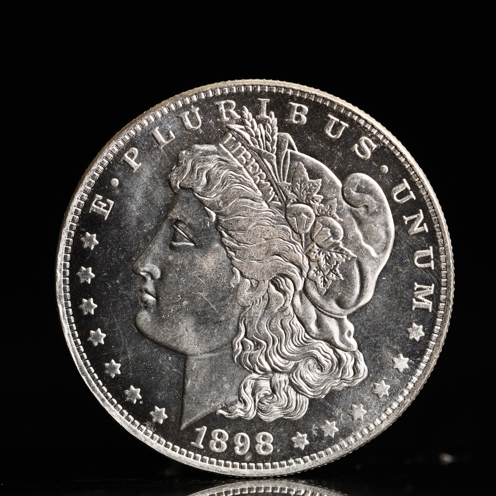 USA Morgan Dollar 1898 Coin: Obv: profile bust with date below and E PLURIBUS UNUM legend and stars around. Rev: eagle with In God we trust above within wreath with UNITED STATES OF AMERICA ONE DOLLAR legend. IN GOD WE TRUST /