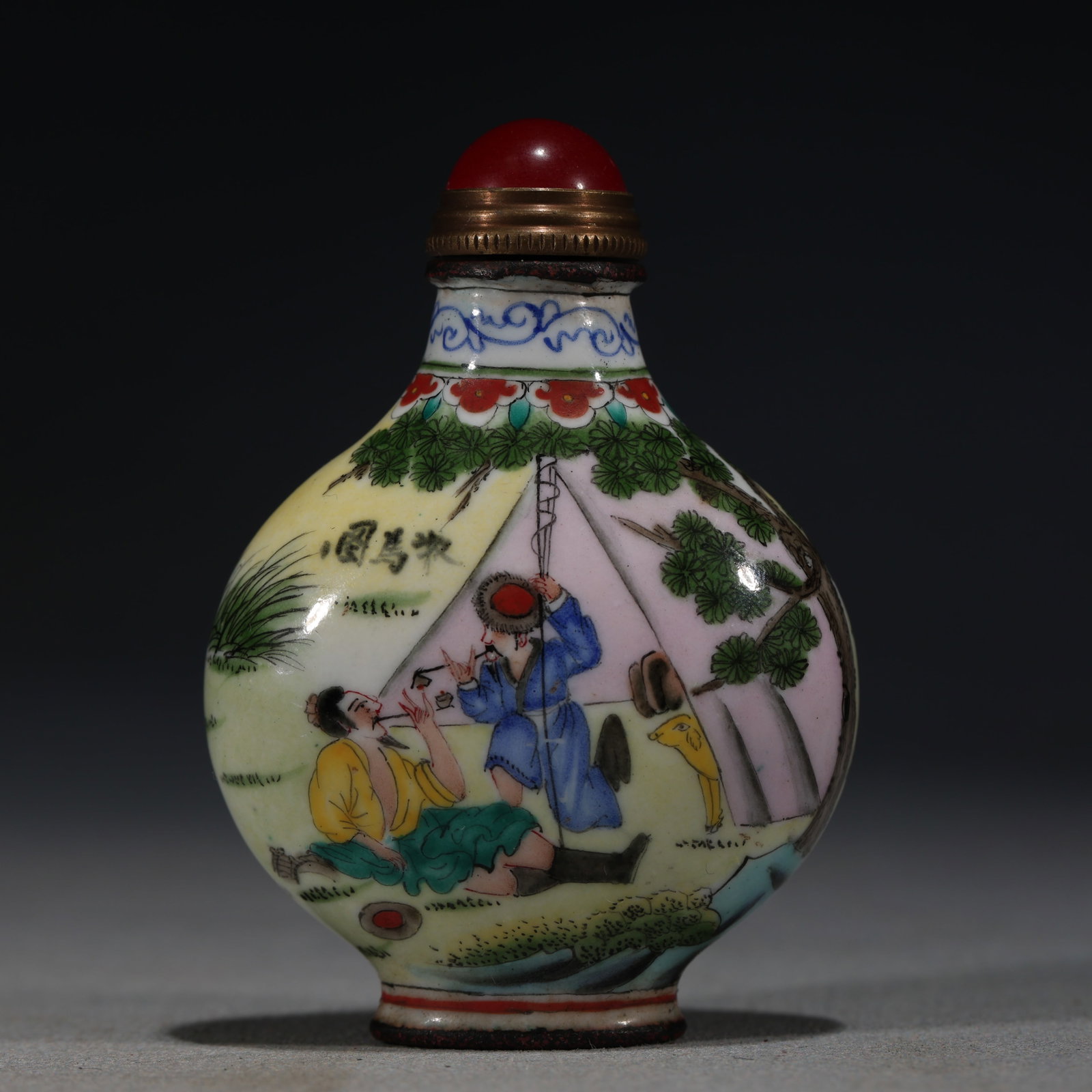 A Chinese Painted Enamel Snuff Bottle with Figures,Qianlong Mark: A Chinese painted enamel snuff bottle,decorated with a scholar seated by a chair and a kneeling boy holding a book.Fitted with a red stopper.The base bears a four-character mark reading(Qianlong Nian 