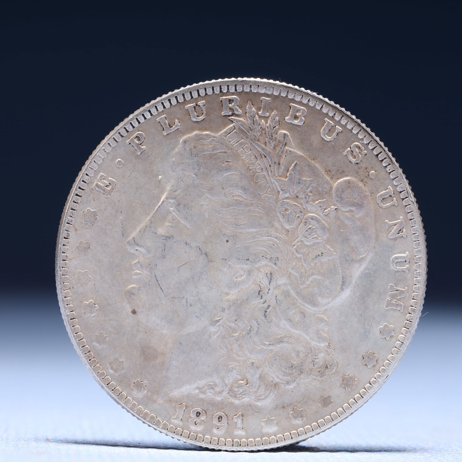 USA Morgan Dollar 1891 Coin: Obv: profile bust with date below and E PLURIBUS UNUM legend and stars around. Rev: eagle with In God we trust above within wreath with UNITED STATES OF AMERICA ONE DOLLAR legend. IN GOD WE TRUST / LI
