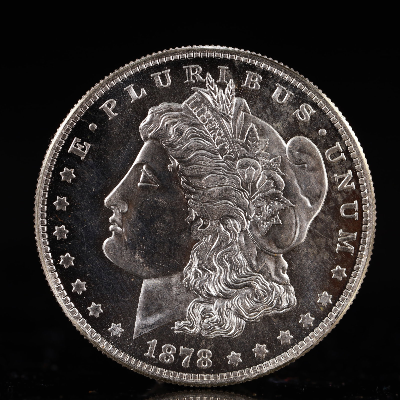 USA Morgan Dollar 1878 Coin: Obv: profile bust with date below and E PLURIBUS UNUM legend and stars around. Rev: eagle with In God we trust above within wreath with UNITED STATES OF AMERICA ONE DOLLAR legend. IN GOD WE TRUST / LI
