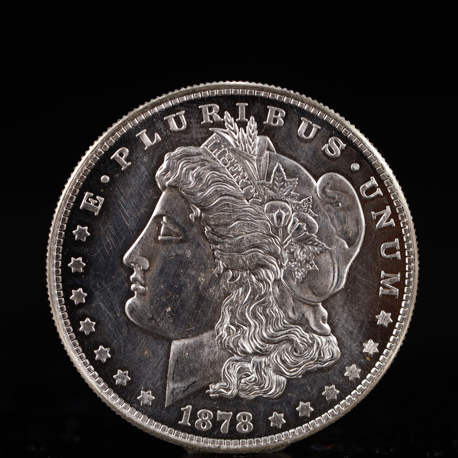 USA Morgan Dollar 1878 Coin: Obv: profile bust with date below and E PLURIBUS UNUM legend and stars around. Rev: eagle with In God we trust above within wreath with UNITED STATES OF AMERICA ONE DOLLAR legend. IN GOD WE TRUST / LI