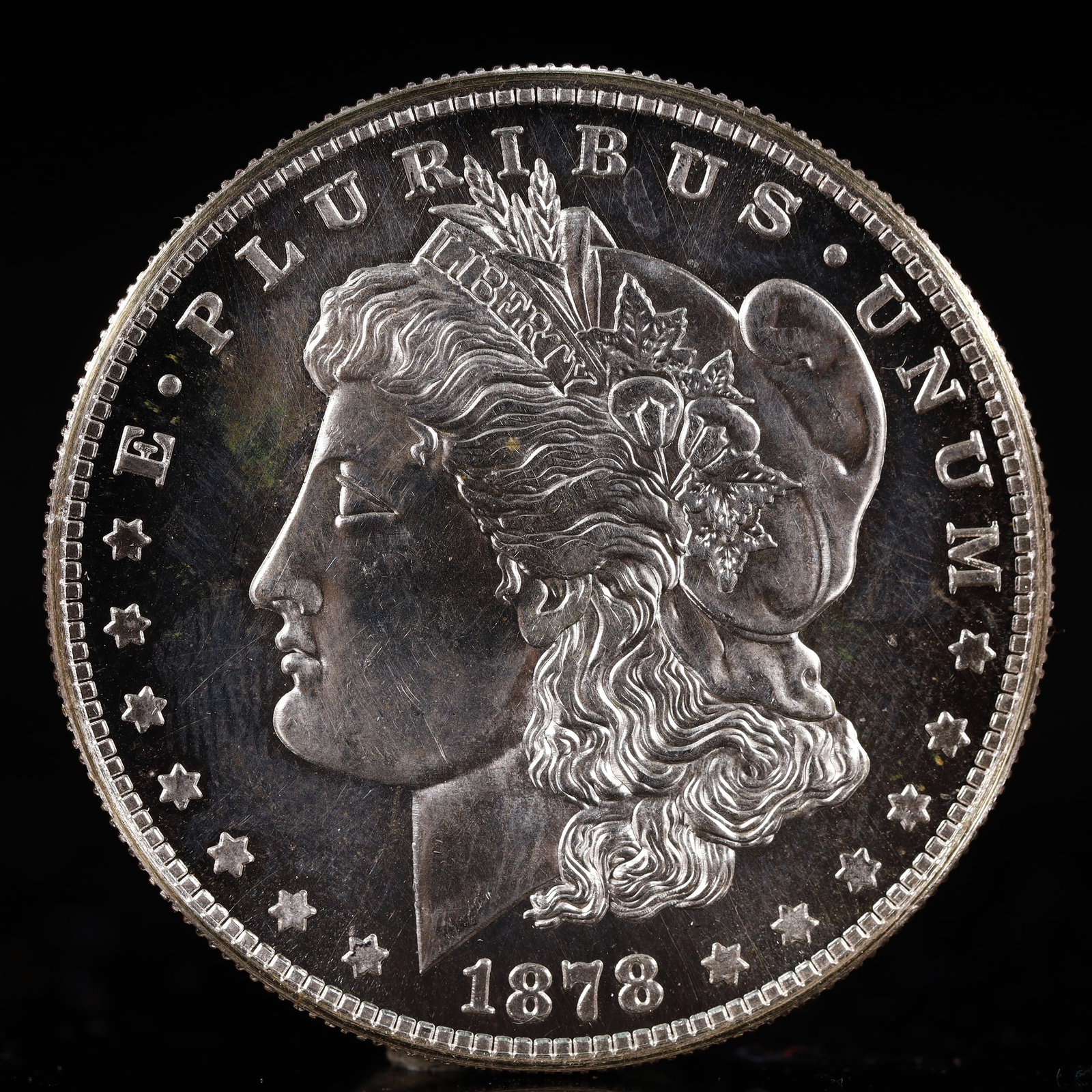 USA Morgan Dollar 1878 Coin: Obv: profile bust with date below and E PLURIBUS UNUM legend and stars around. Rev: eagle with In God we trust above within wreath with UNITED STATES OF AMERICA ONE DOLLAR legend. IN GOD WE TRUST / LI