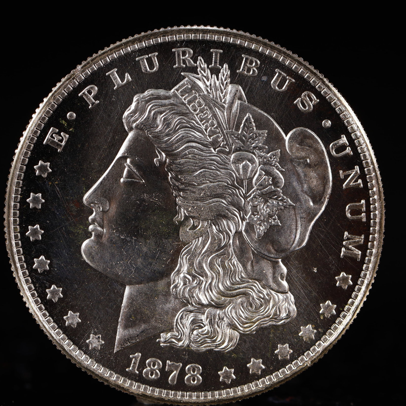 USA Morgan Dollar 1878 Coin: Obv: profile bust with date below and E PLURIBUS UNUM legend and stars around. Rev: eagle with In God we trust above within wreath with UNITED STATES OF AMERICA ONE DOLLAR legend. IN GOD WE TRUST / LI
