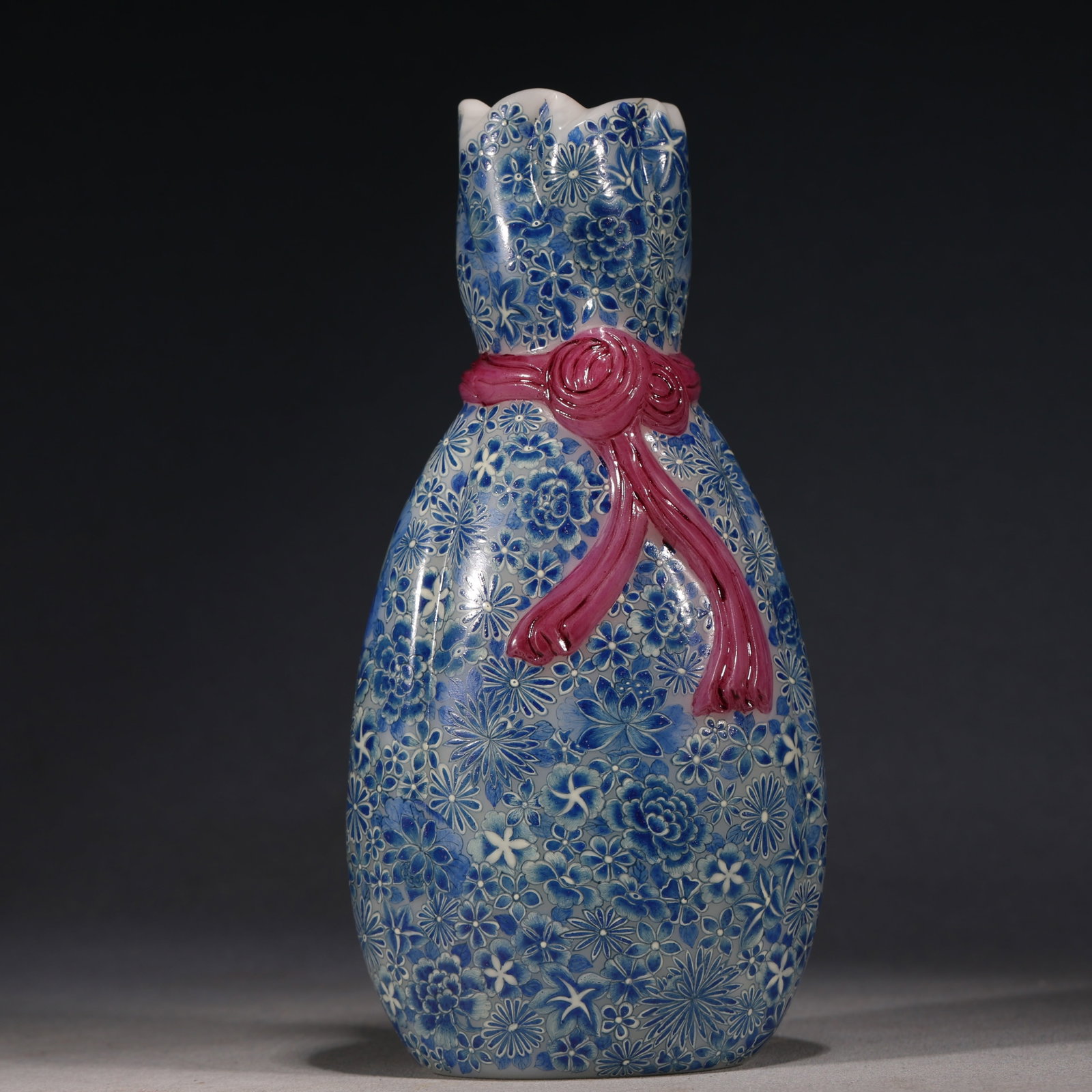 An Exquisite Glass Body Blue And White Hundred Flowers Famille Rose Cloth Bundle Vase With Ribbon: An Exquisite Glass Body Blue And White Hundred Flowers Famille Rose Cloth Bundle Vase With Ribbon Ornament，China, Qing Dynasty, Four-Character Qianlong Mark, Dimensions: 6.3inx2.4inx7.9in, Weig