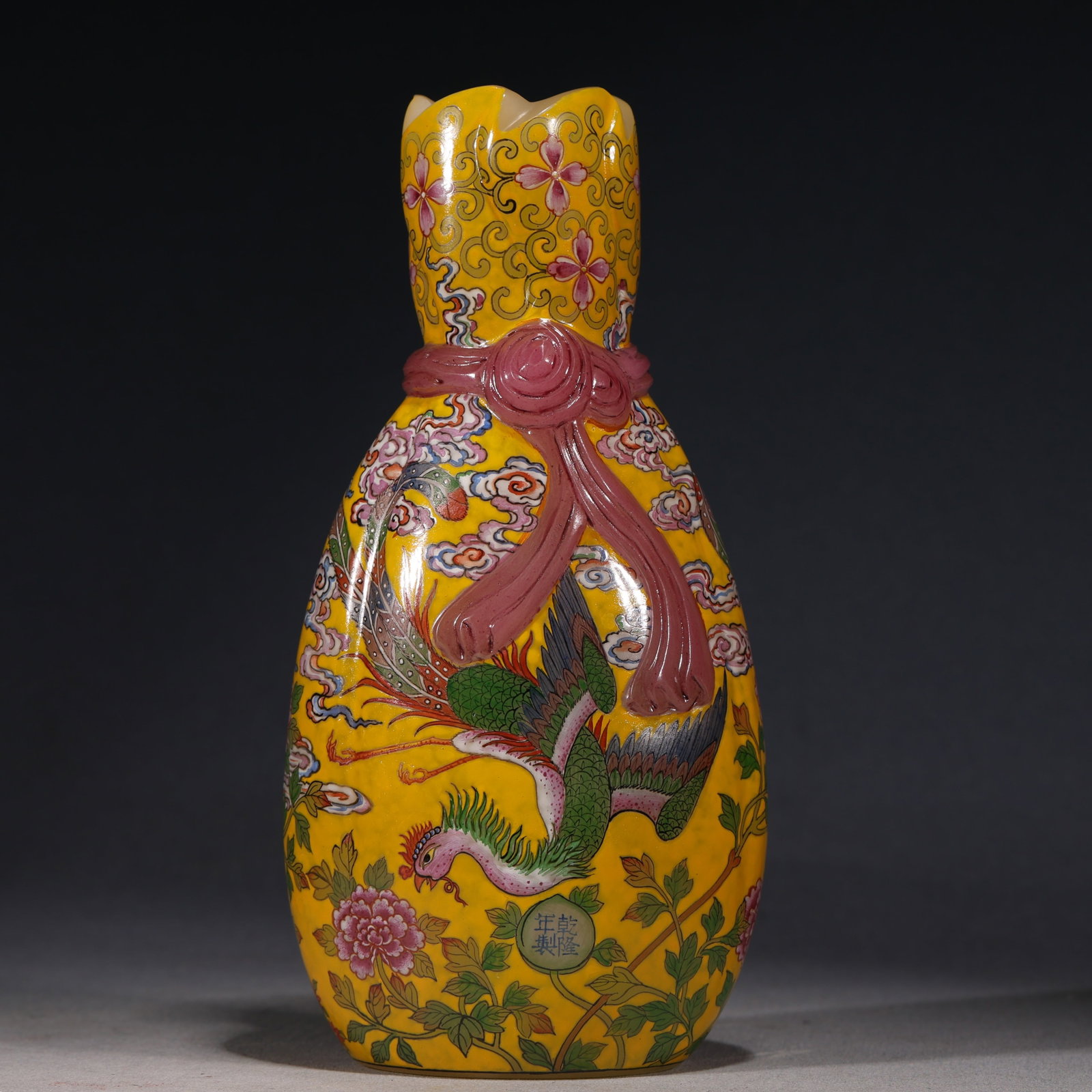 An Exquisite Glass Body Yellow Ground Enamel Cloth Bundle Vase With Phoenix Flying Among Peonies: An Exquisite Glass Body Yellow Ground Enamel Cloth Bundle Vase With Phoenix Flying Among Peonies Pattern，China, Qing Dynasty, Four-Character Qianlong Mark, Dimensions: 6.3inx2.4inx7.9in,