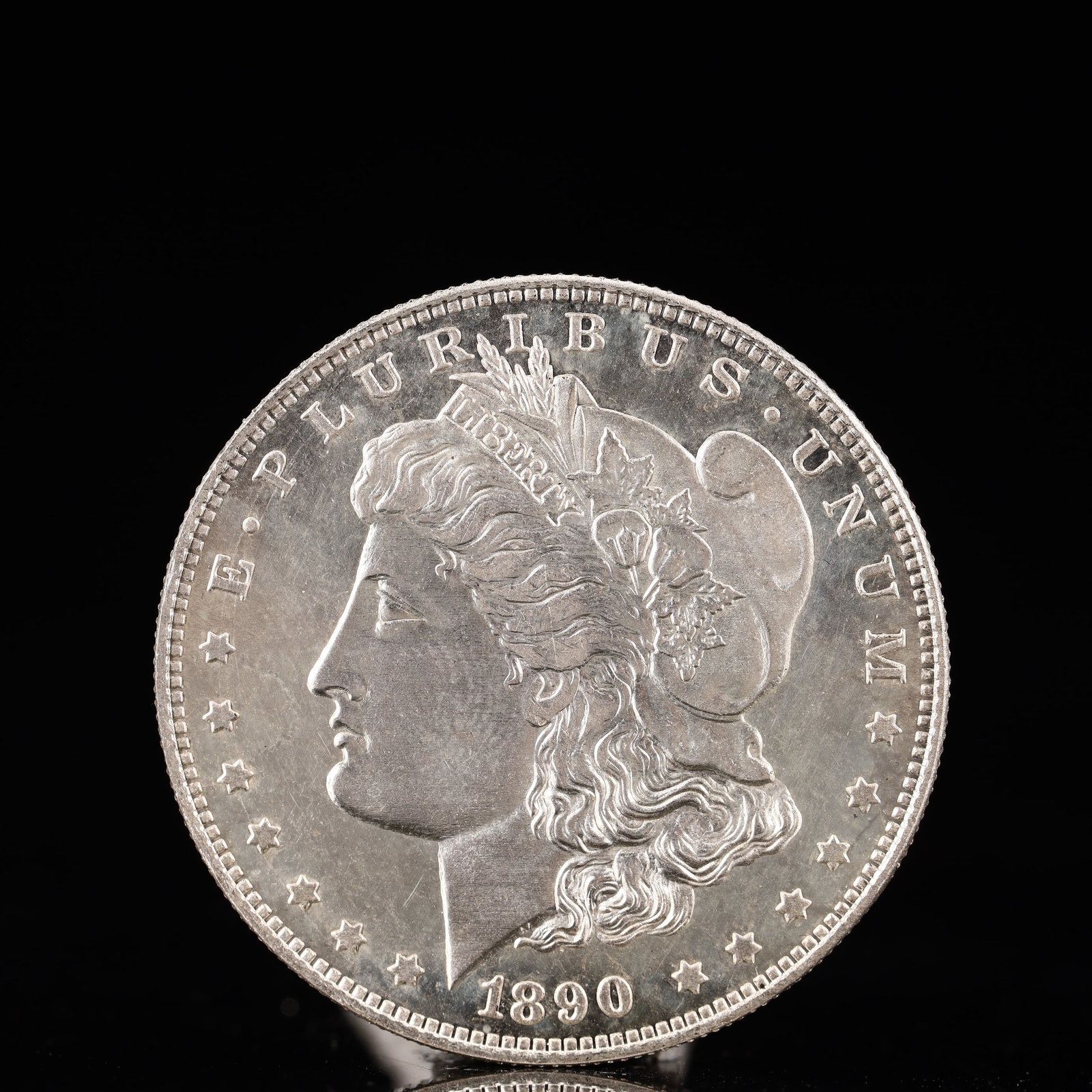 USA Morgan Dollar 1890 Coin: Obv: profile bust with date below and E PLURIBUS UNUM legend and stars around. Rev: eagle with In God we trust above within wreath with UNITED STATES OF AMERICA ONE DOLLAR legend. IN GOD WE TRUST / LI