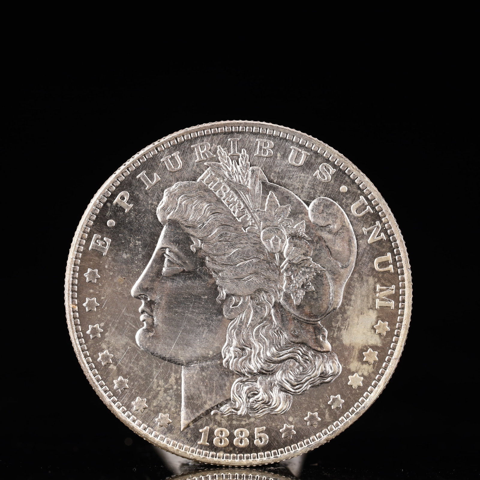 USA Morgan Dollar 1885 Coin: Obv: profile bust with date below and E PLURIBUS UNUM legend and stars around. Rev: eagle with In God we trust above within wreath with UNITED STATES OF AMERICA ONE DOLLAR legend. IN GOD WE TRUST / LI