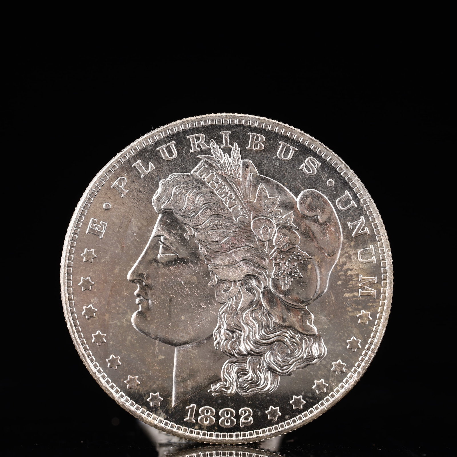USA Morgan Dollar 1882 Coin: Obv: profile bust with date below and E PLURIBUS UNUM legend and stars around. Rev: eagle with In God we trust above within wreath with UNITED STATES OF AMERICA ONE DOLLAR legend. IN GOD WE TRUST /