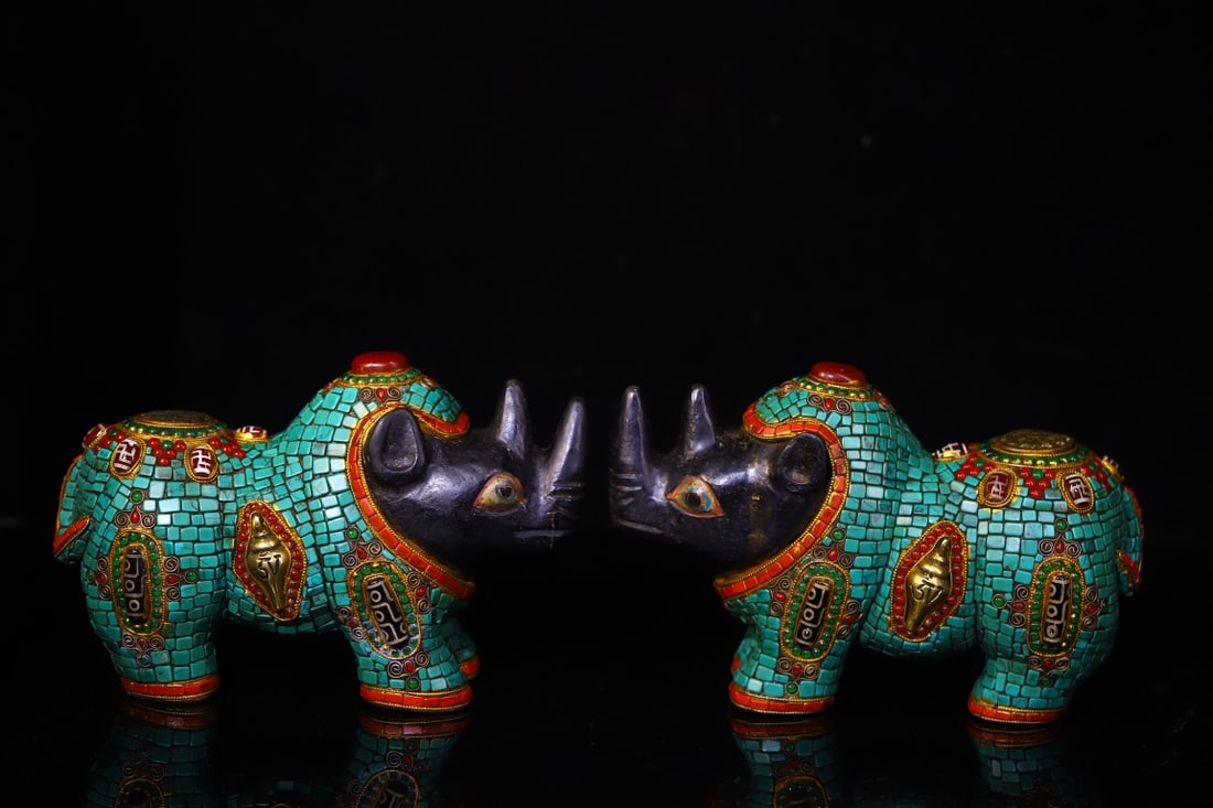 A Pair of Exquisite Meteorite Inlaid Dzi Bead and Turquoise Rhinoceros Ornaments: A Pair of Exquisite Meteorite Inlaid Dzi Bead and Turquoise Rhinoceros Ornaments,Qing Dynasty,China,Size:5.5inx8.3in,Weight:6000g一对陨石镶天珠和绿