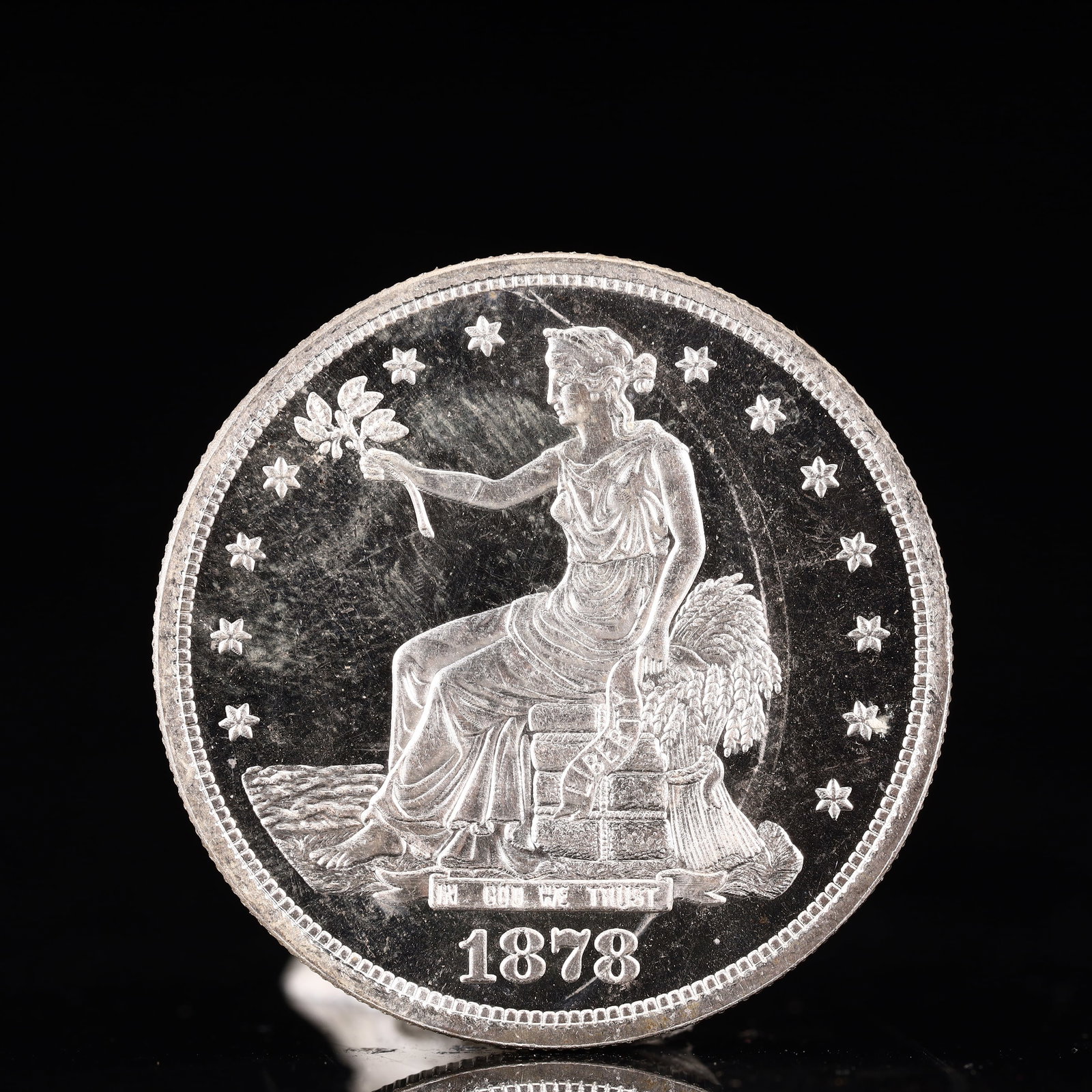 USA Trade Dollar 1878 Coin: American coin. Obverse: Liberty seated on a pedestal facing the sea to the left holding olive branches surrounded by 13 stars. IN GOD WE TRUST / LIBERTY / 1878. Reverse: An eagle holding branches with