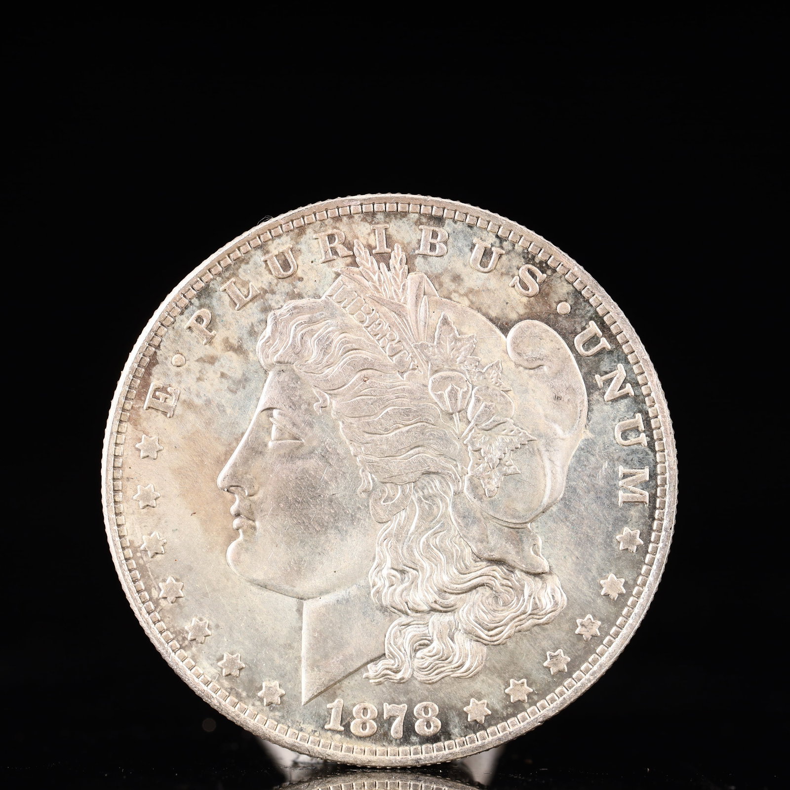 USA Morgan Dollar 1878 Coin: Obv: profile bust with date below and E PLURIBUS UNUM legend and stars around. Rev: eagle with In God we trust above within wreath with UNITED STATES OF AMERICA ONE DOLLAR legend. IN GOD WE TRUST / LI