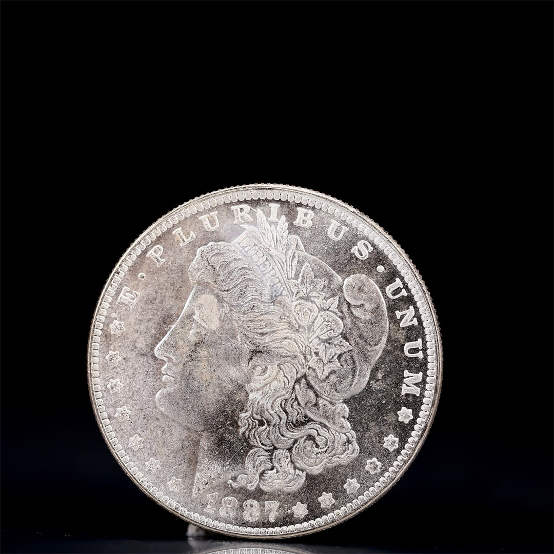 USA Morgan Dollar 1887 Coin: Obv: profile bust with date below and E PLURIBUS UNUM legend and stars around. Rev: eagle with In God we trust above within wreath with UNITED STATES OF AMERICA ONE DOLLAR legend. IN GOD WE TRUST /