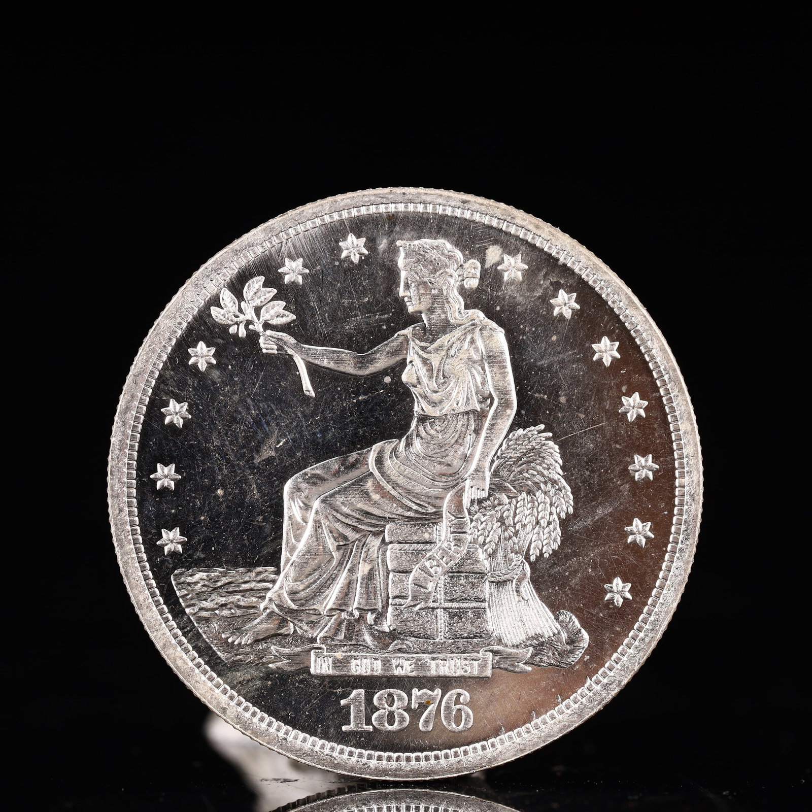 USA Trade Dollar 1876 Coin: American coin. Obverse: Liberty seated on a pedestal facing the sea to the left holding olive branches surrounded by 13 stars. IN GOD WE TRUST / LIBERTY / 1876. Reverse: An eagle holding branches with