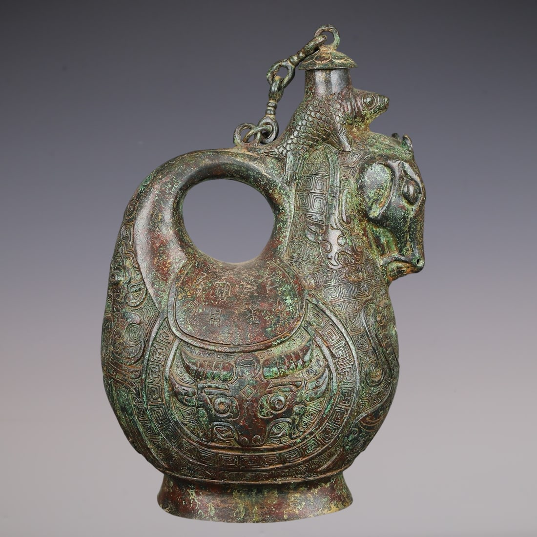 An Archaic Bronze Beast-Face Pattern Horse-head Pot,With Inscription: An Archaic Bronze Beast-Face Pattern Horse-head Pot,With Inscription,Han Dynasty, China,Size:7.9inx4.7inx12.6in,Weight:2820g青铜兽面纹马首壶,带