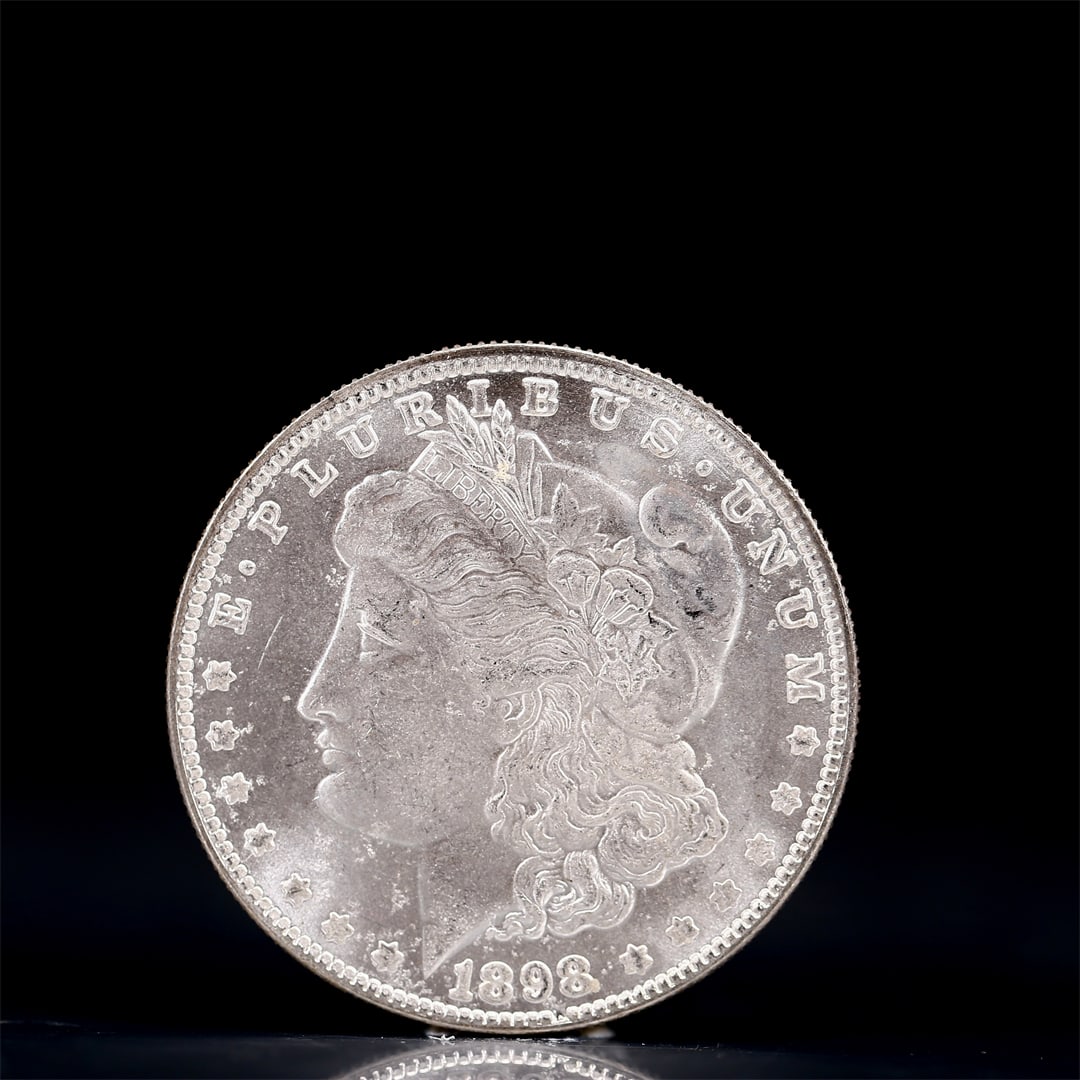 USA Morgan Dollar 1898 Coin: Obv: profile bust with date below and E PLURIBUS UNUM legend and stars around. Rev: eagle with In God we trust above within wreath with UNITED STATES OF AMERICA ONE DOLLAR legend. IN GOD WE TRUST / LI