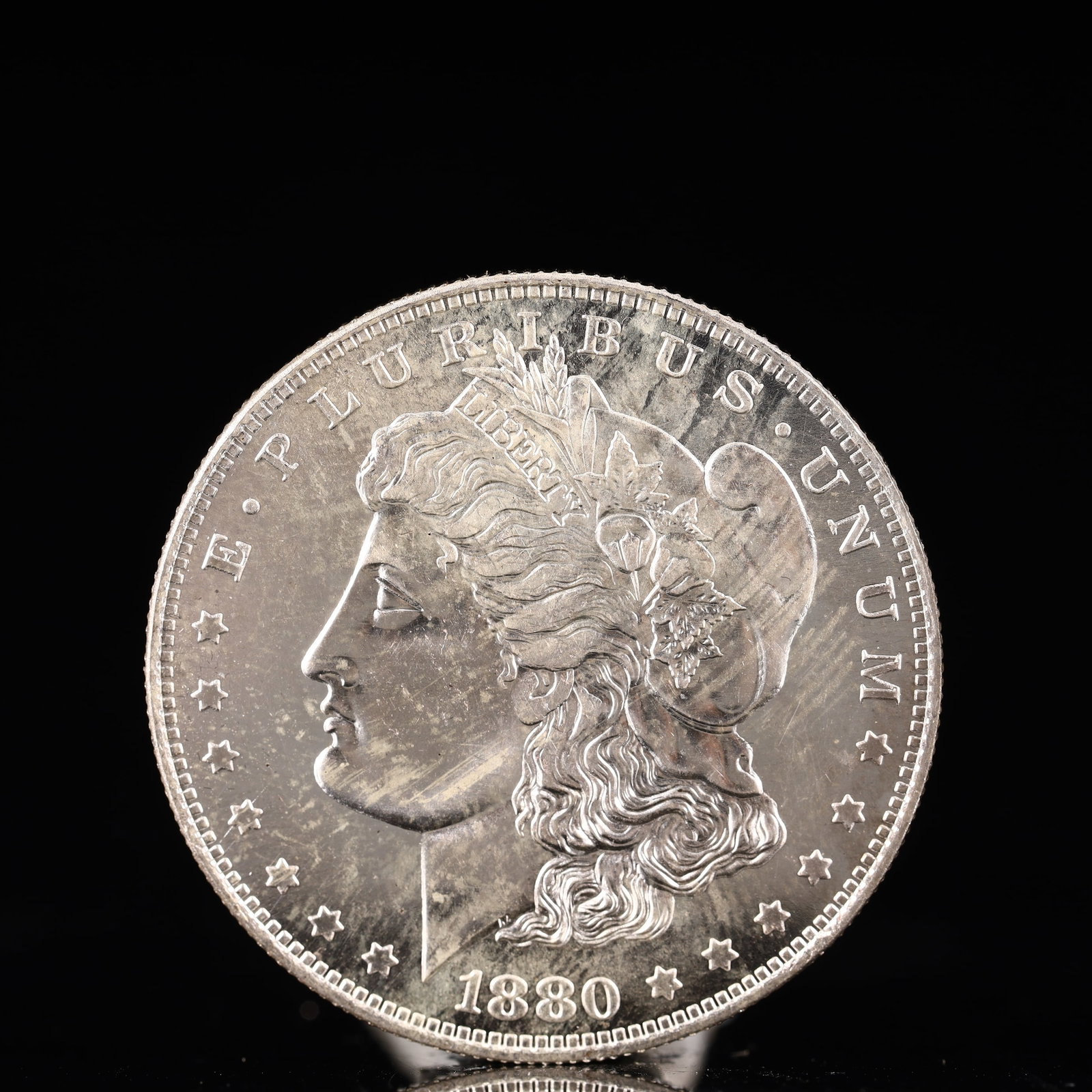 USA Morgan Dollar 1880 Coin: Obv: profile bust with date below and E PLURIBUS UNUM legend and stars around. Rev: eagle with In God we trust above within wreath with UNITED STATES OF AMERICA ONE DOLLAR legend. IN GOD WE TRUST / LI