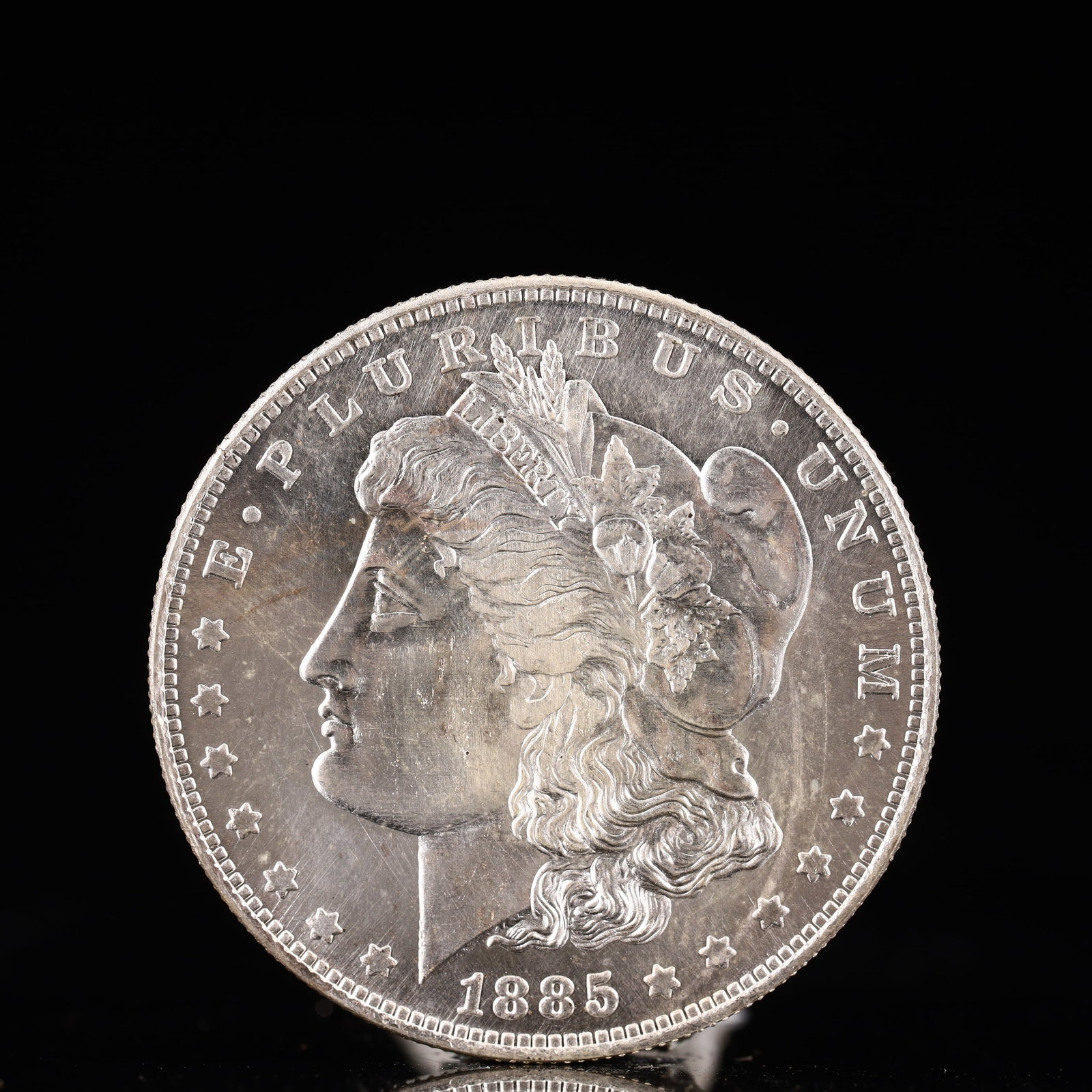 USA Morgan Dollar 1885 Coin: Obv: profile bust with date below and E PLURIBUS UNUM legend and stars around. Rev: eagle with In God we trust above within wreath with UNITED STATES OF AMERICA ONE DOLLAR legend. IN GOD WE TRUST /