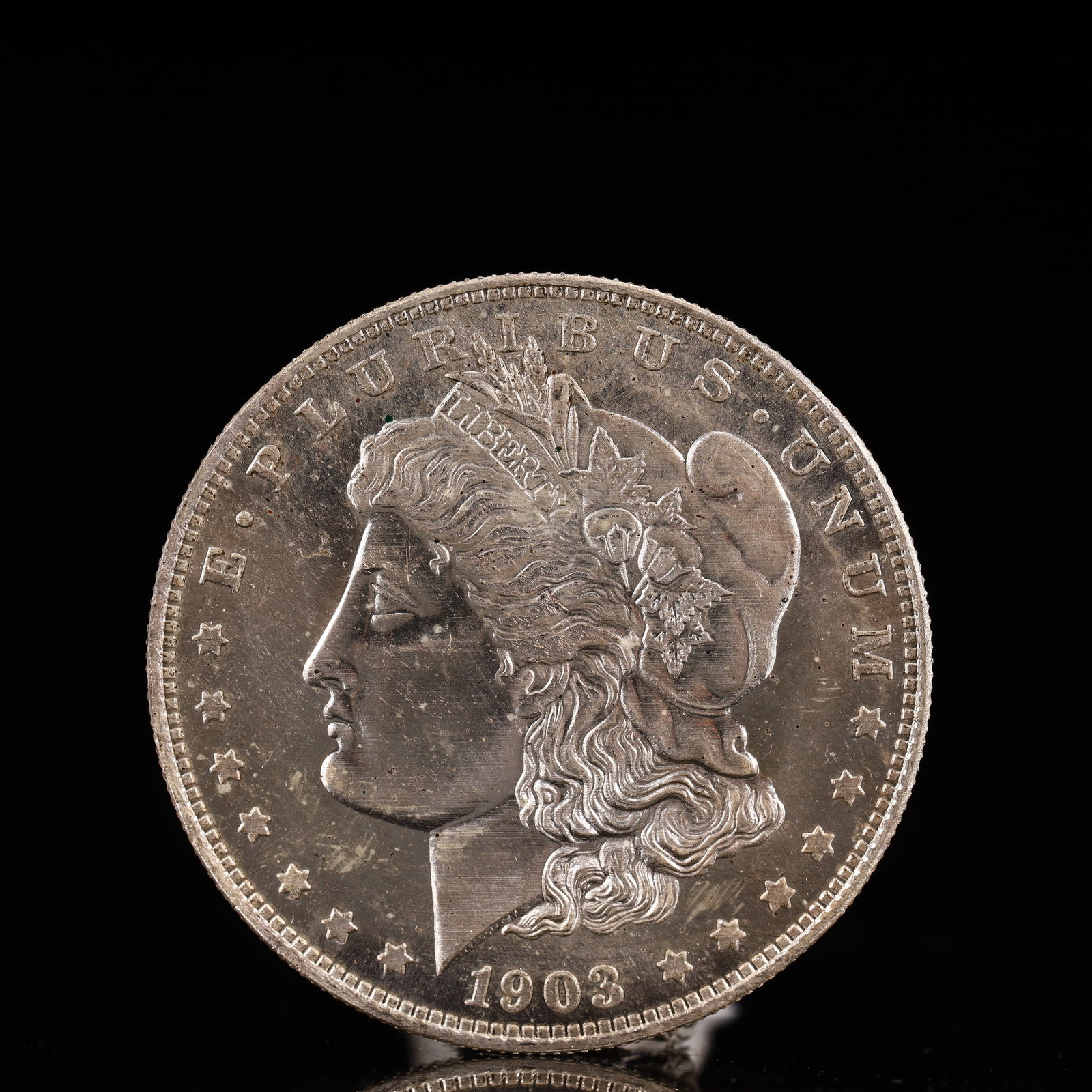 USA Morgan Dollar 1903 Coin: Obv: profile bust with date below and E PLURIBUS UNUM legend and stars around. Rev: eagle with In God we trust above within wreath with UNITED STATES OF AMERICA ONE DOLLAR legend. IN GOD WE TRUST / LI