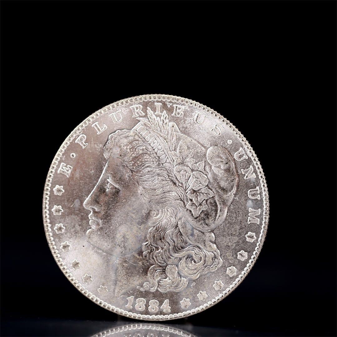 USA Morgan Dollar 1884 Coin: Obv: profile bust with date below and E PLURIBUS UNUM legend and stars around. Rev: eagle with In God we trust above within wreath with UNITED STATES OF AMERICA ONE DOLLAR legend. IN GOD WE TRUST / LI