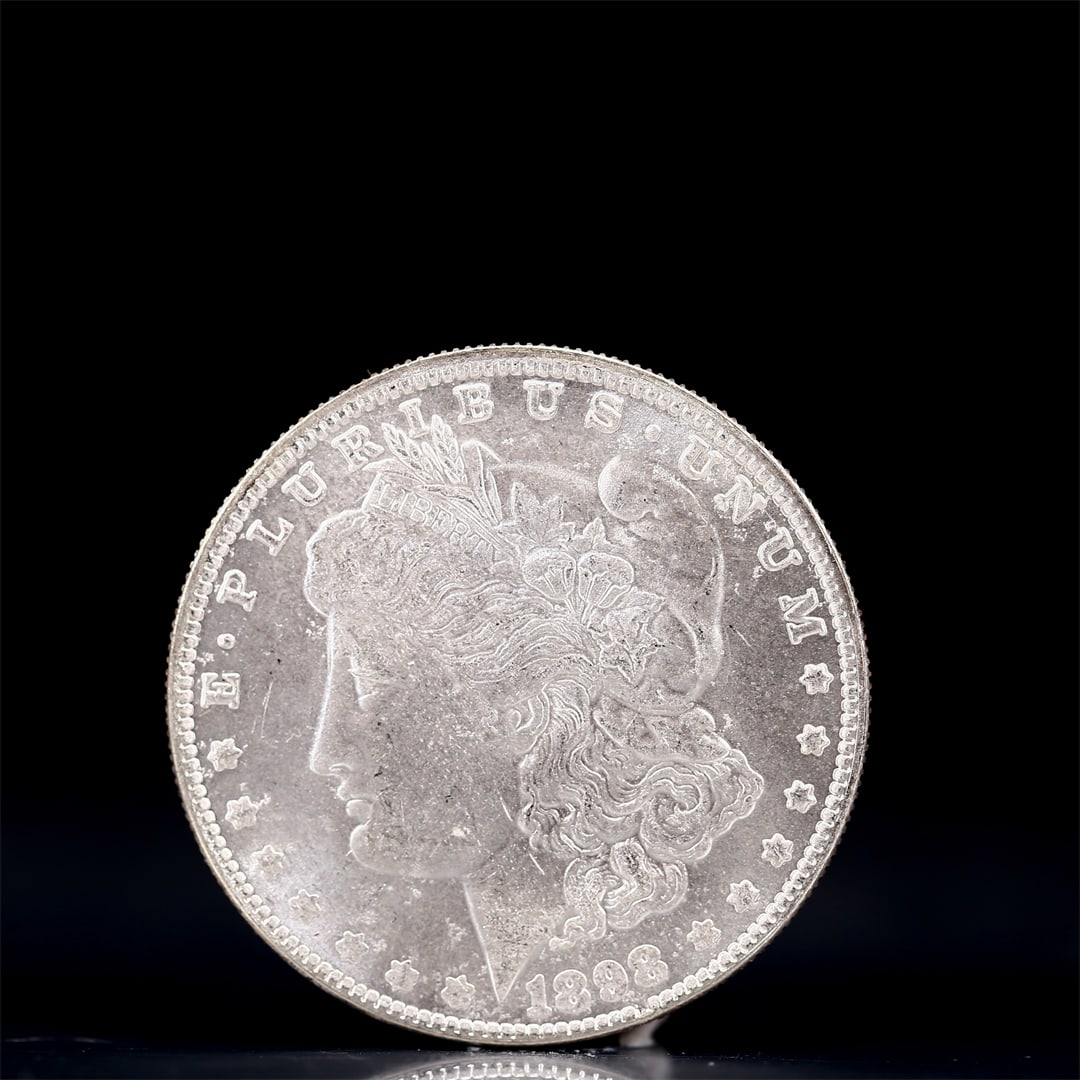 USA Morgan Dollar 1898 Coin: Obv: profile bust with date below and E PLURIBUS UNUM legend and stars around. Rev: eagle with In God we trust above within wreath with UNITED STATES OF AMERICA ONE DOLLAR legend. IN GOD WE TRUST / LI