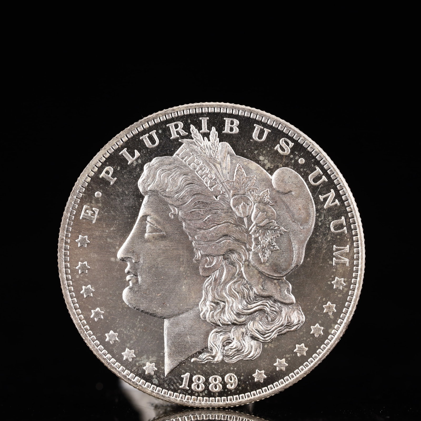 USA Morgan Dollar 1889 Coin: Obv: profile bust with date below and E PLURIBUS UNUM legend and stars around. Rev: eagle with In God we trust above within wreath with UNITED STATES OF AMERICA ONE DOLLAR legend. IN GOD WE TRUST / LI