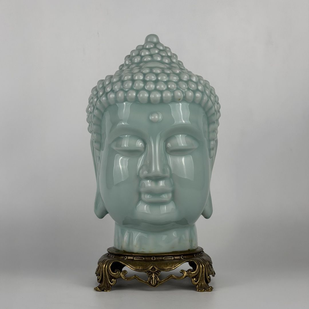 An Exquisite Celadon Glazed Copper-Inlaid Buddha Head: An Exquisite Celadon Glazed Copper-Inlaid Buddha Head,Qing Dynasty, China,Size:15inx7.9inx7.1in 粉青釉镶铜佛首,中国清代