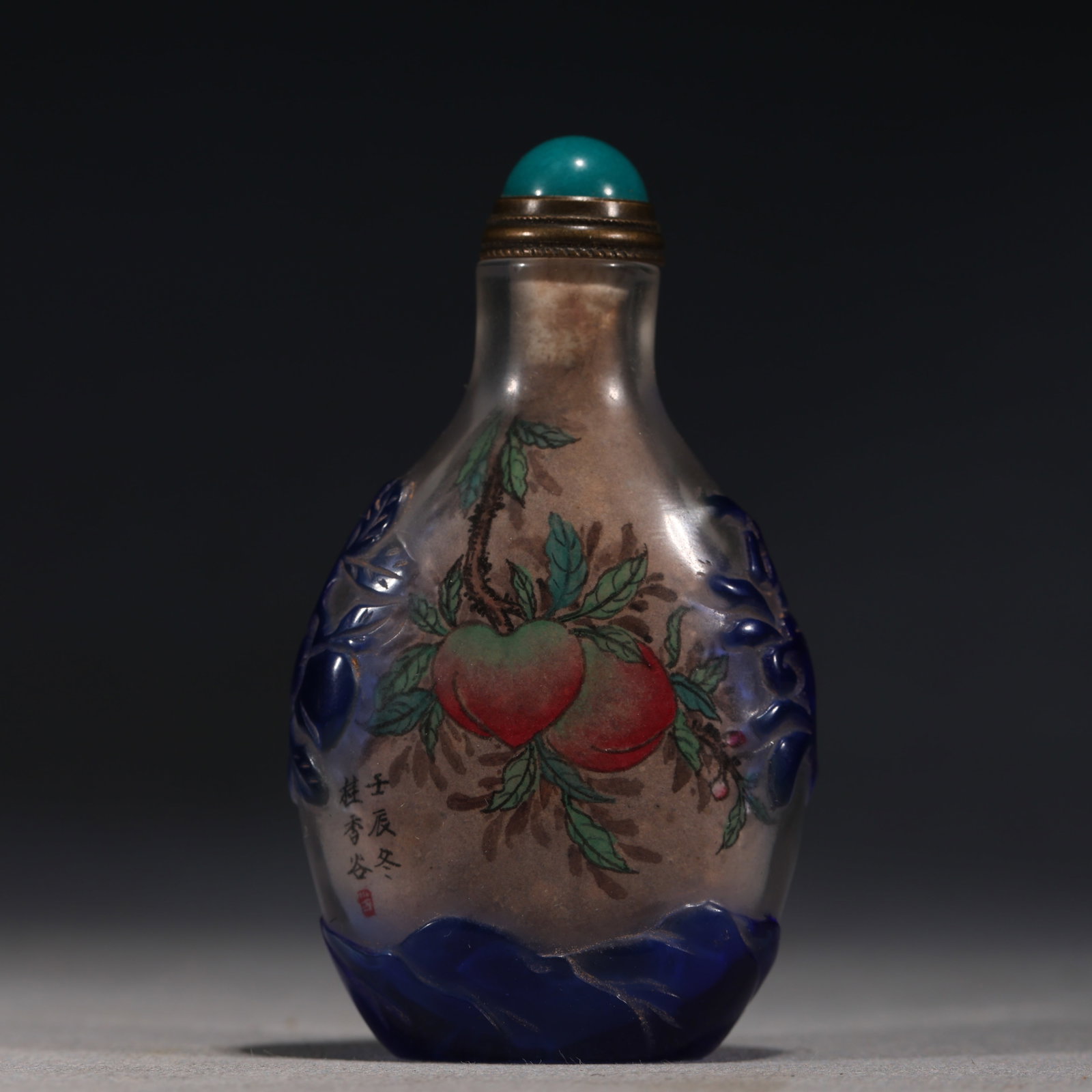 A Chinese Inside-Painted Blue Overlay Glass Snuff Bottle with Birds,Renchen Year: An inside-painted blue overlay glass snuff bottle,painted with birds perched on a branch,inscribed Jia Ou and Renchen Dong signature.Fitted with a red stopper.The base is