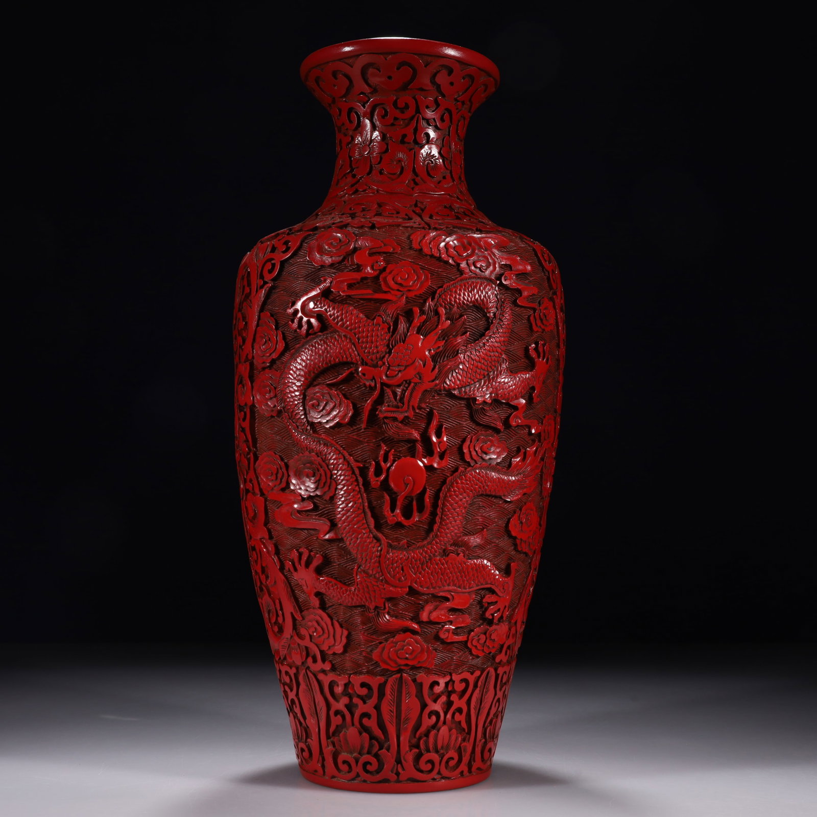 A Carved Cinnabar Lacquer Vase with 'Sea, Cliff, Cloud and Dragon' Motif: The entire vase is carved in red lacquer. The central belly is dominated by a vigorous front-facing five-clawed dragon, soaring among dense clouds, waves, and mountain cliffs, chasing a flaming