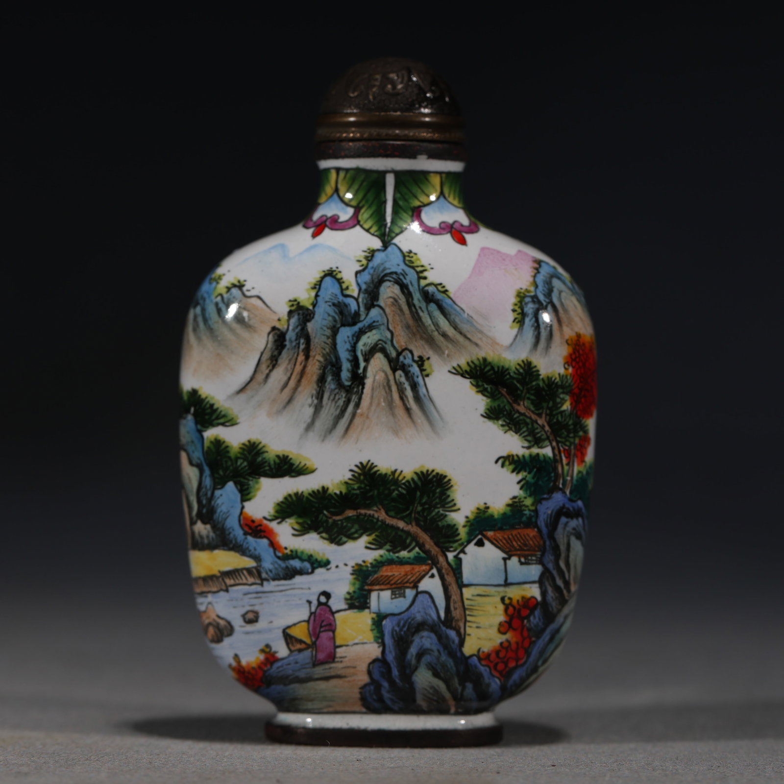 A Chinese Painted Enamel Snuff Bottle with Landscape and Pavilion,Qianlong Mark: A painted enamel snuff bottle,decorated with a continuous landscape including a pavilion,a bridge,and a figure fishing.Fitted with a bronze stopper.The base bears a four-character mark reading(Qianlon