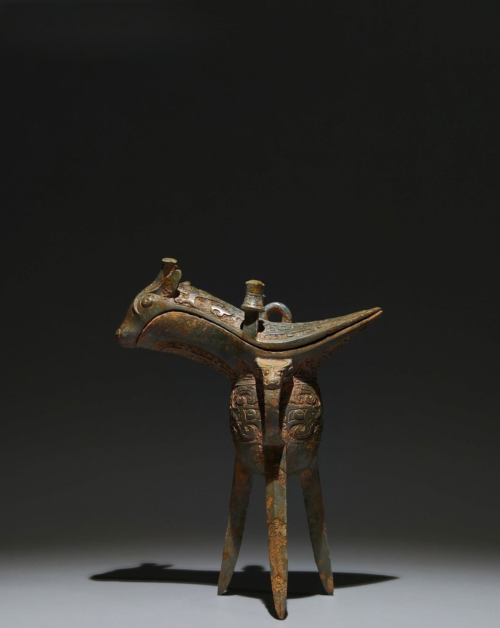 An Archaic Bronze Beast-Face Pattern Tripod Goblet: An Archaic Bronze Beast-Face Pattern Tripod Goblet,Shang Dynasty,China,Size:8.5inx6.7inx3in 青铜兽面纹三足爵杯,中国商代