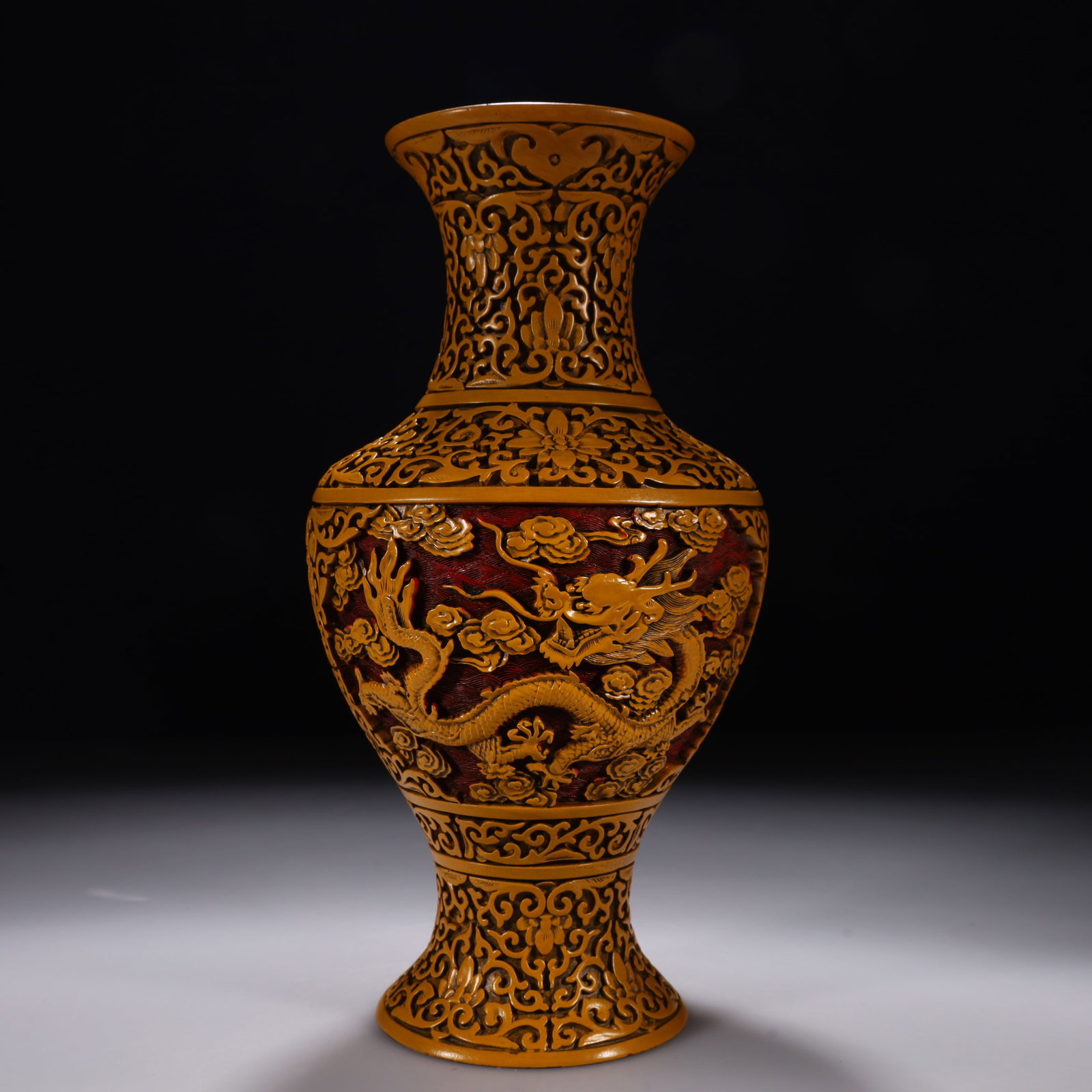 A Carved Yellow Lacquer Vase with Cloud and Dragon Motif: Of dignified form, covered overall in carved yellow lacquer (unlike standard red). The neck is detailed with lotus scrolls. The belly is carved with a majestic five-clawed dragon writhing amongst vibr