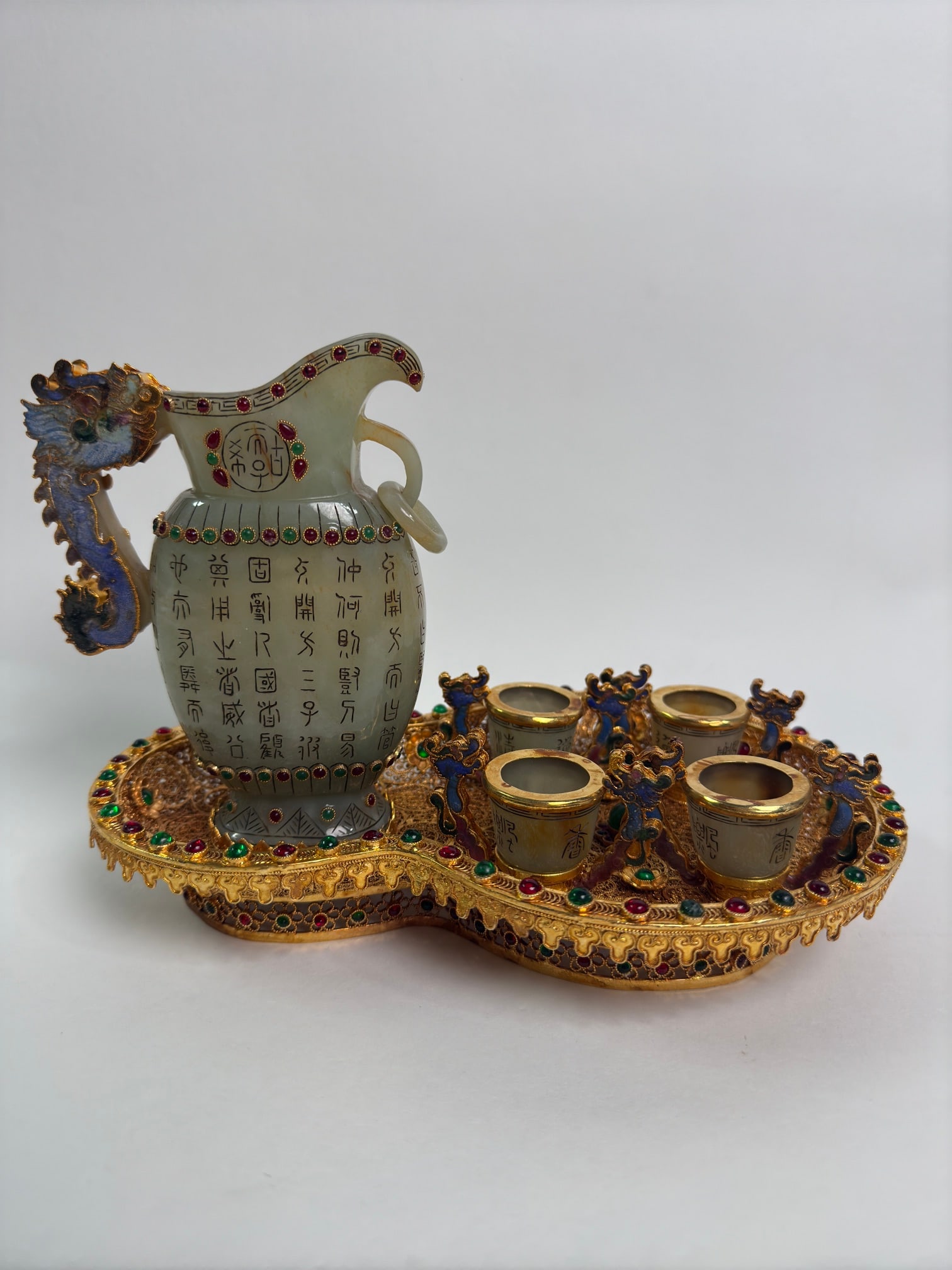 A Set of Fine Filigree and Gilding Inlaid White Jade Wine Vessels,With Inscription: A Set of Fine Filigree and Gilding Inlaid White Jade Wine Vessels,With Inscription,Qing Dynasty,China,Qianlong Four-character Mark,Size:(entirety)7.1inx6.3inx9.4in,(Flagon)5.9inx4.5in,(Libation Cup)1.