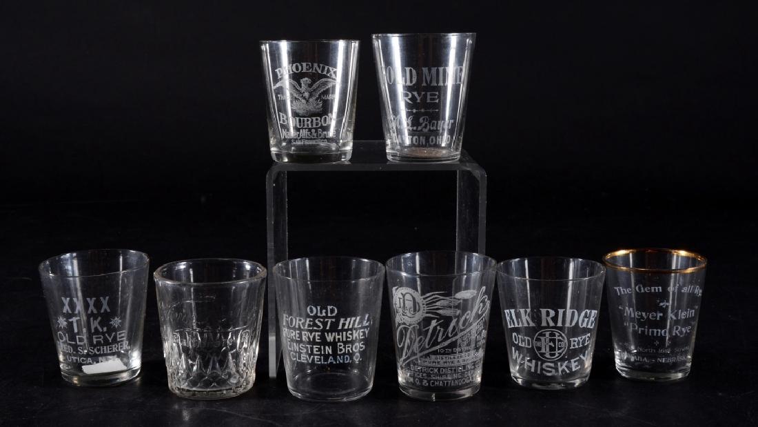 8 Vintage Advertising Shot Glasses: Phoenix Bourbon, Forest Hill Rye, Elk Ridge Rye, Meyer Klein Primo Rye 2" high w/worn gold edge, Gold Mine Rye, King Old Baltimore Rye, XXXTK Old Rye and Detrick Rye & Bourbon.