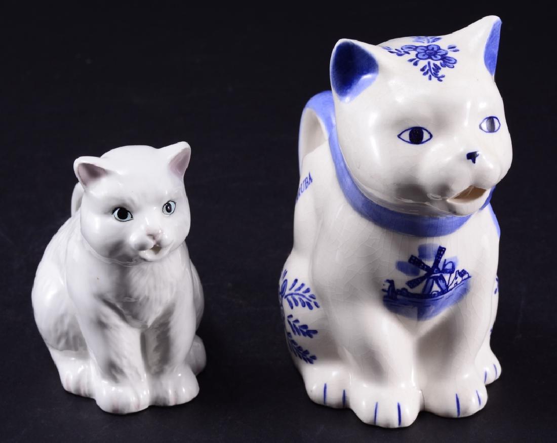 Two Sitting Cat Creamers: White cat creamer 3 1/2" tall x 4 1/4" long; Blue & white cat creamer mark on bottom, 5 7/8" tall x 5" long.