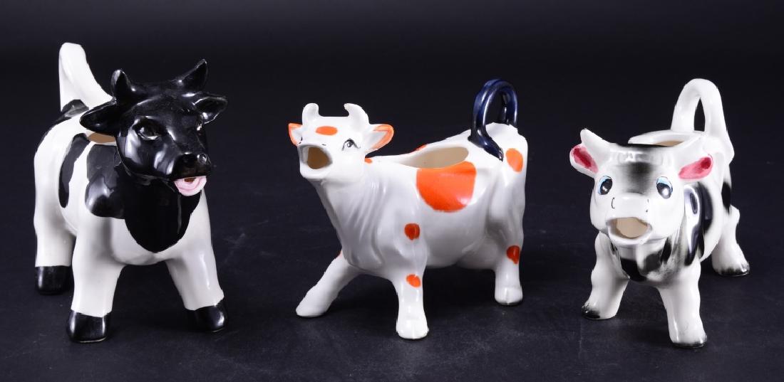 3 Spotted Cow Creamers: Largest black spotted creamer 7" long paper tagged Made in Taiwan, orange spotted creamer 6" long paper tagged Made in Japan and smaller black spotted creamer 6.5" long.