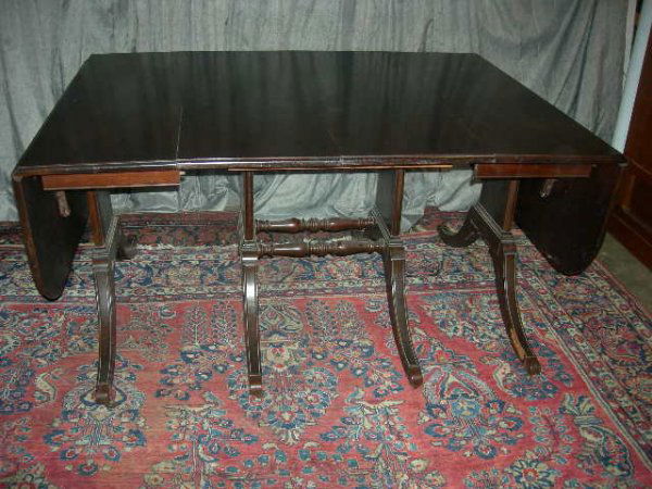 MAHOGANY DROP LEAF DINING ROOM TABLE: Mahogany Drop Leaf Dining RoomTable w/8 Duncan Phyfe Style Legs w/Brass Casters & Wooden Wheels; Turned Stretchers, 41.75"W X 28"D X 29.5"T; w/Both Drops Up 56.5"D; Each Leaf 14"D; 3 Leaves; Opens Up
