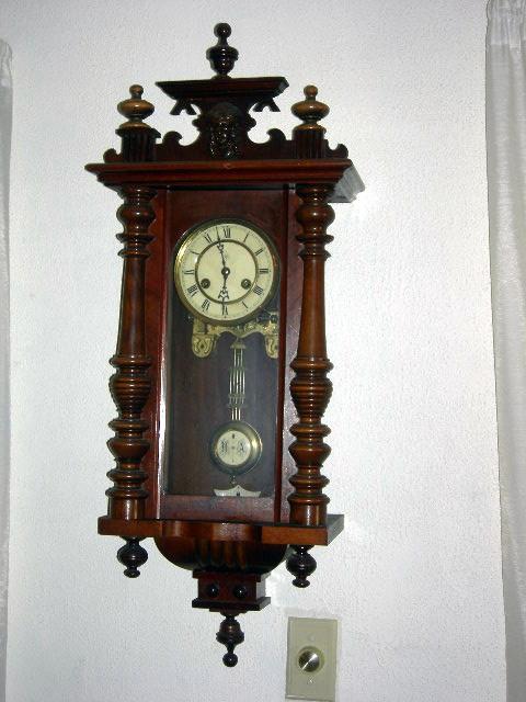 REGULATOR CLOCK: Regulator Wall Clock Marked RA, Topped w/Finials and Centered Mask, Large Half Round Stiles, Drop at Bottom, 14" Wide x 32" Tall.