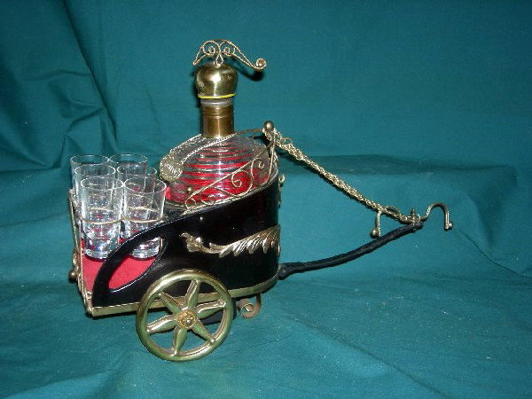 CHARIOT MUSICAL DECANTER SET: Reeded Glass Pouring Decanter w/Decorative Helmet Cover and 6 Shot Glasses, All Housed in Metal Felt Lined Chariot w/Chain Reins That is a Music Box, 15.5" Long x 10.75" Tall.