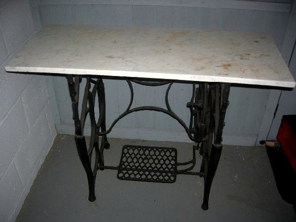 MARBLE TOP & SEWING MACHINE STAND: White Marble Top, 40" x 16.5"; Cast Iron Sewing Machine Stand w/Treadle on Metal Casters, 22.5" Wide x 17" Deep x 28.5" Tall.