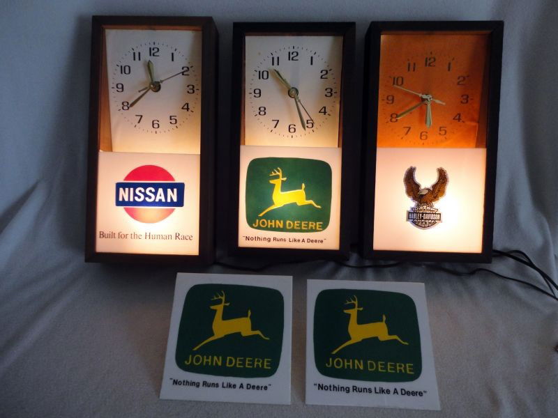 WOOD FRAMED ADVERTSING CLOCKS: 3 Hand Assembled Electric Lighted Advertising Clocks w/"Lanshire Synchronous Self Starting Electric Clock Movement" Inc. 1 "Nissan Built For The Human Race," 1 "John Deere Nothing Runs Like A Deere,"