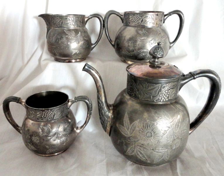 SILVER PLATED TEA SET: Silver Plated Tea Set w/Etched Fruit & Flower Design Inc. Covered Tea Pot, Creamer, Sugar, & Waste, Marked Pairpoint Mfg Co. Quadruple Plate, 3.75"T To 8"T.