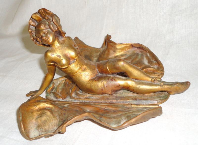WOOLWORTH BUILDING ADVERTISING LADY: Brass Reclining Lady in Flowing Robe w/Woolworth Building Shield and Ruffled Night Cap, Robe Opens to Reveal Bare Chested Lady in Under Garment, Stamped on Base JB 2039, 5.5" L x 3" T.