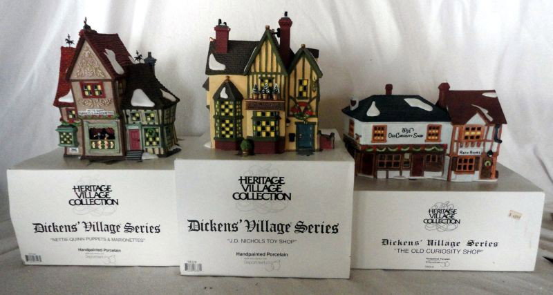 DEPT 56 DICKENS' VILLAGE SERIES: Heritage Village Lot w/Light Cords and Original Boxes Includes Nettie Quinn Puppets & Marionettes, 8" T; The Old Curiosity Shop Rare Books, 6" T; J. D. Nichols Toy Shop, 8" T.