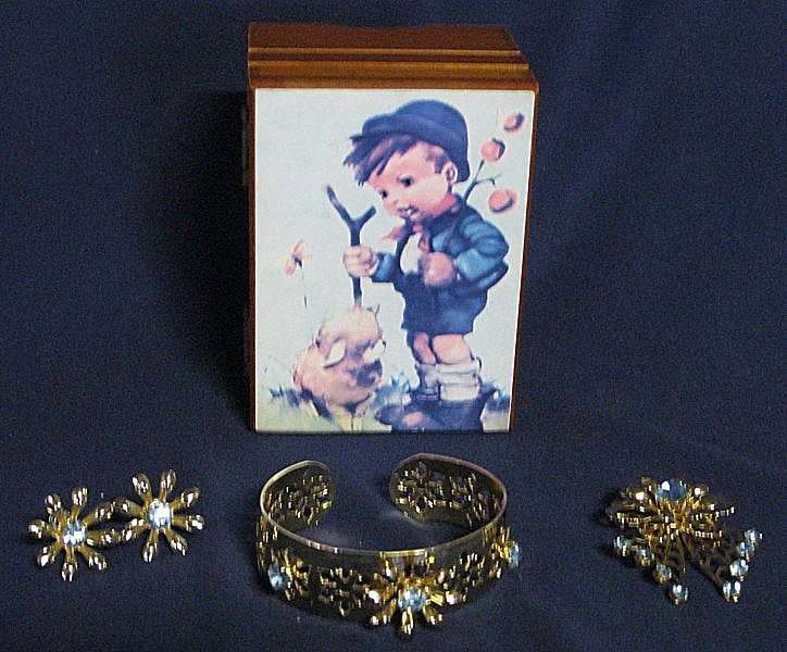 LADIES FOUR PIECE COSTUME JEWELRY W/JEWELRY BOX: 4 Piece Gold Tone w/Blue Stone, Floral Design Jewelry, Inc. Broach, Earrings & Bracelet; and wood music box, Hummel print top, marked Japan, Plays "Somewhere My Love," 4"W x 2.5"T.