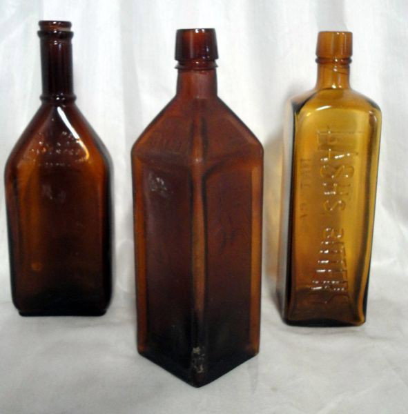 THREE BROWN GLASS BOTTLES: Lot Inc. 1872 Doyles Hop Bitters Bottle, 1 Side Embossed w/Leaf & Berry Design; Lashs Bitters Natural Tonic Laxative; & Royal Quality Bottle Made In USA Patented Aug. 28th 1916, All 9.5"T.