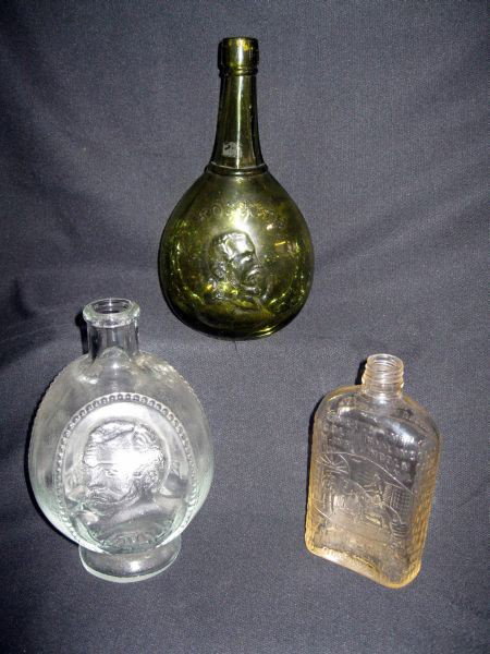THREE FLASK BOTTLES: Inc. Dark Green Bulbous, Embossed w/”Kossuth,” & Male Bust One Side, Tree On Other, 10.25”T; Clear 3-Sided Bottle , Embossed w/Busts: “John L.,” “The Babe,” & “Thorpe, 8.5”T.; Lincol