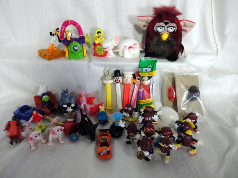 COLLECTIBLE TOY LOT: Over 30 Various Toys Including. 1999 Original Furby, Paper & Plastic Tags; 5 PEZ, 1 in Original Wrapper; Hot Wheels Olds Aurora GTS-1; 11 California Raisin Men and Much More.