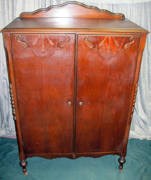ARMOIRE: Dark Finish 2 Door Armoire, Left Interior Has 3 Drawers & Upper & Lower Storage, Right Side Open w/Metal Pole For Hung Clothing, Back Splash, Turned Front Feet, Metal Casters On All, 40”W X 20”D X