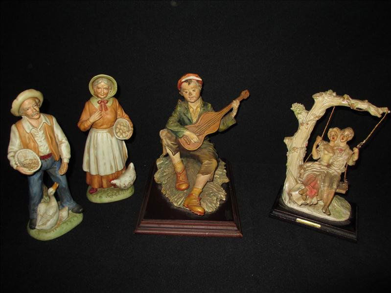 Four Figurines: Four Figurines Include A 8.25 x 6 x 8 Troubadour With A Blue "Crown N" Mark On Side That Is Mounted On Wood, The 8 x 5 x 3.5" Girl and Boy On Swing Marked "By Miriam", The 8 x 3.25 x 2.5" Man Feeding